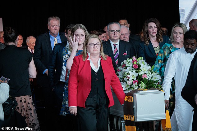 Mrs Carter's coffin is seen draped over it with an AFL Hawthorn Hawks team scarf