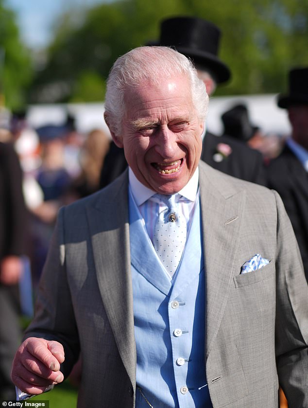 King Charles III speaks to guests attending a Royal Garden Party at Buckingham Palace on the same day Harry was in the UK