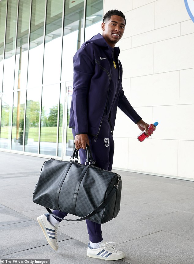 Bellingham arrives for an England training session in June with a Louis Vuitton bag in one hand and a bottle of Lucozade in the other, wearing Adidas trainers.