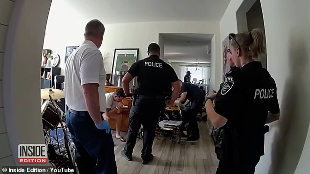 Paramedics attend to Scholtes' two-year-old daughter after she was left in a hot car for three hours while her father played video games