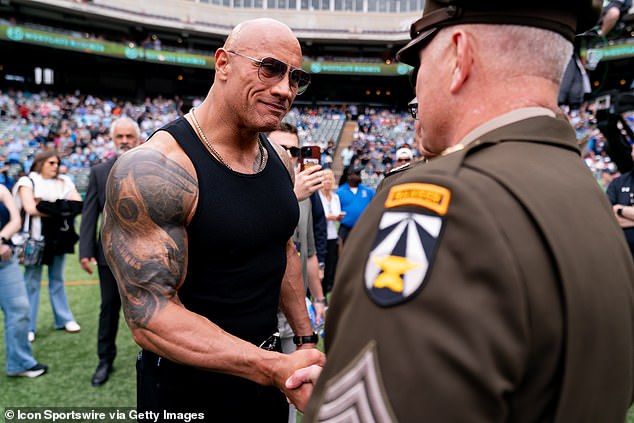 UFL owner Dwayne 'The Rock' Johnson shakes hands with military personnel before a UFL game