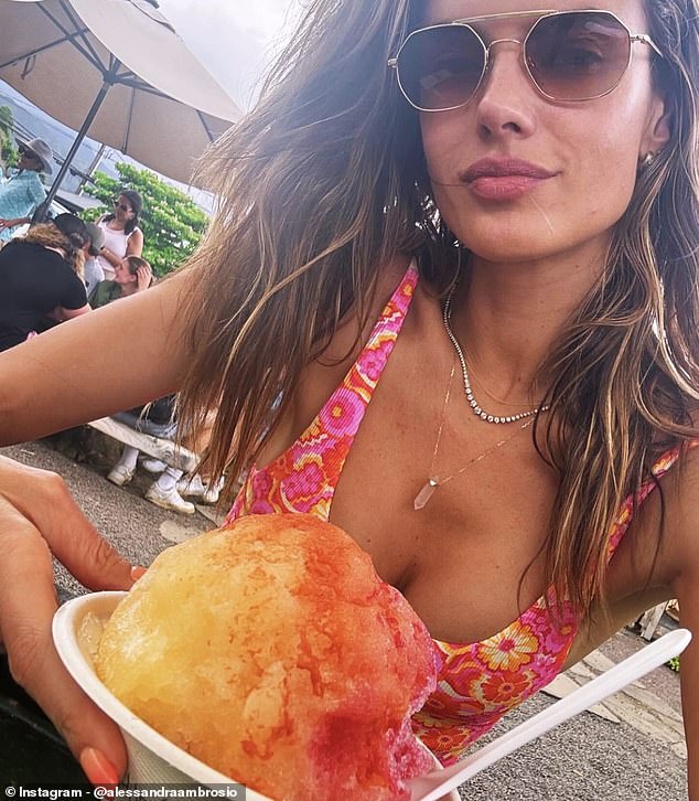 Wearing a pink floral swimsuit and a light pink crystal necklace, Alessandra enjoyed some frozen fruit