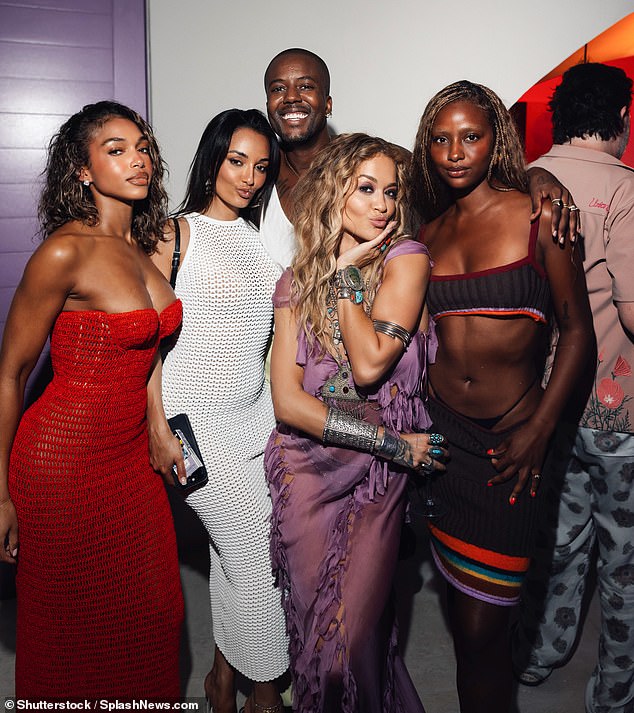 In a less casual photo, Rita was seen pouting next to singer Justine Skye and fashion designer Amina Muaddi and others as the evening drew to a close.