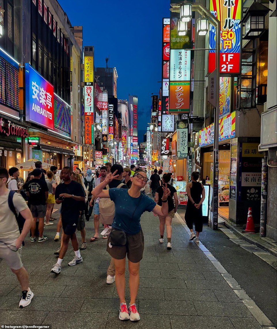 She was seen wearing her glasses while making two peace gestures on a busy street. 'Pretend you're for Tokyo.'