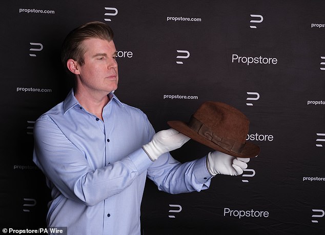 Top of the props: An auctioneer holds up the famous hat during the auction in Los Angeles