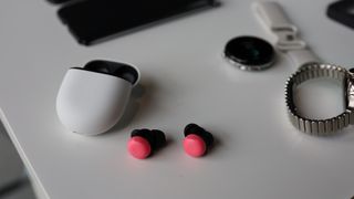 Google Pixel Buds Pro 2 in pink, on a desk