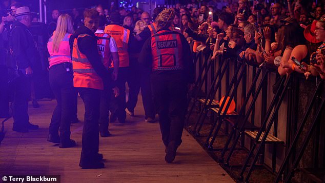 The camera then zoomed in on the crowd, where several security guards could be seen pulling a blond person over the fence and then escorting him off the festival grounds.