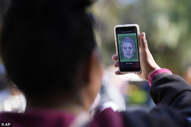 A migrant from Michoacan, Mexico, uses the CBPOne app on Tuesday, January 24, 2023, in Tijuana, Mexico.