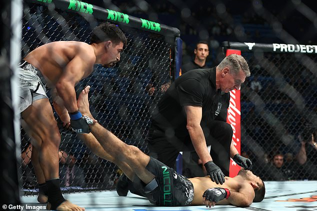 Aguilar (left) showed great sportsmanship as he manipulated Nicoll's legs to get the blood flowing back to his head in terrifying scenes immediately after his victory