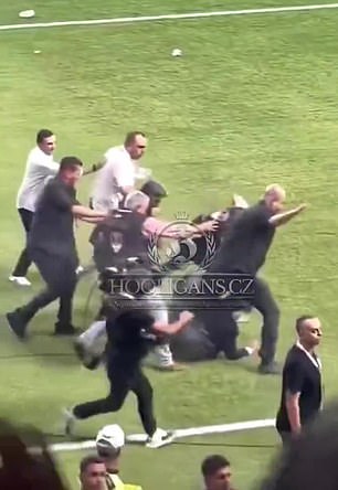 The video shows Koc, who is being escorted off the field, being pushed to the ground before being hit by an object thrown from the crowd.