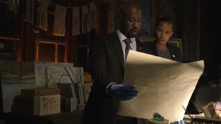 Erik and Chelsea from The Night Agent inspect a document