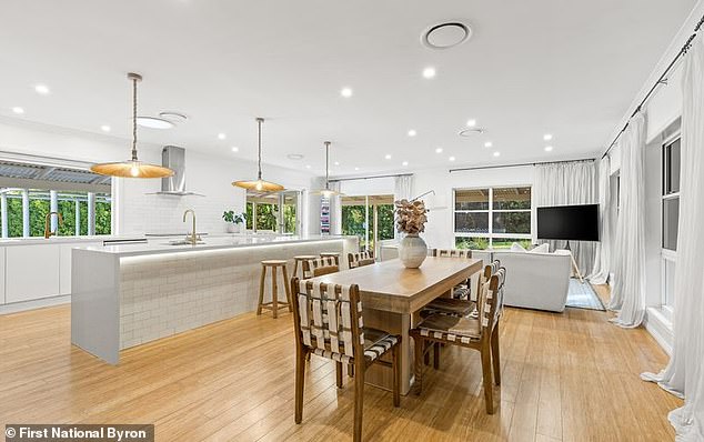 A sleek, modern kitchen with walk-in closet, induction hob, stone countertops and a spacious island