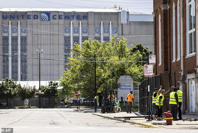 Workers set up fencing around the United Center in preparation for the DNC