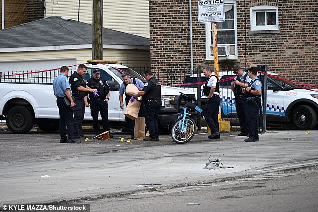 Officers were seen at the scene of a daytime shooting in Chicago on Saturday afternoon, treating one of at least 11 shooting victims who would be shot over the weekend - 3 fatally