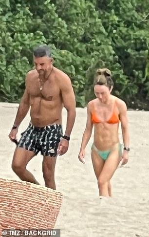 The Ukrainian-born beauty showed off her toned abs in an orange triangle bikini top and sea green string bikini bottoms