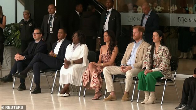 Meghan remained subdued as they watched the performance, displaying good posture as she appeared focused on the dance