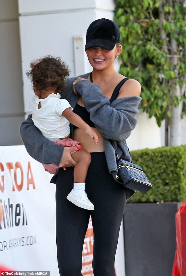 Chrissy was dressed for comfort and function in a black sports bra and matching leggings with a gray zip-front hoodie