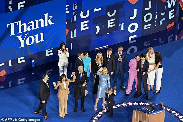 President Joe Biden raises his hands with Vice President Kamala Harris as family members flood the stage after he finished his speech at the Democratic National Convention Monday night