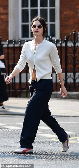 She completed her look with navy pants and sneakers, while shielding her eyes with dark sunglasses.