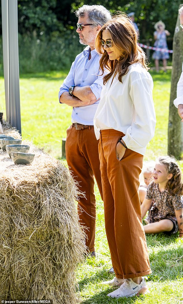 Queen Mary, 52, looked effortlessly elegant in a white shirt, rust-coloured trousers and chunky trainers.