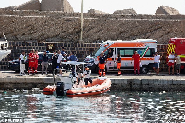 Emergency services can be seen in the harbor, near where the boat sank Monday morning