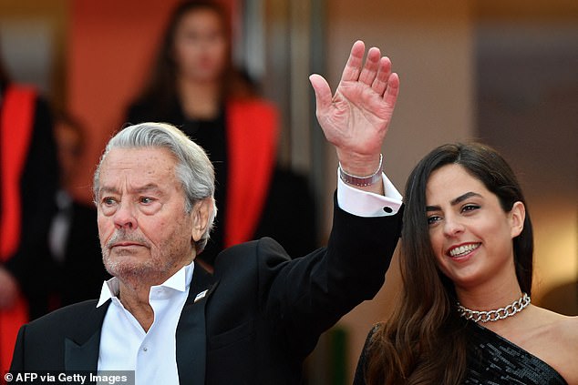 French actor Alain Delon waves as he arrives with his daughter Anouchka Delon to receive an Honorary Palme d'Or at the 72nd Cannes Film Festival in Cannes, southern France, on May 19, 2019