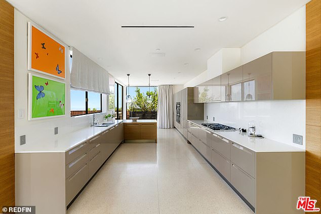 The Beverly Hills home's kitchen also features dual ovens and floating, gloss-finish cabinets with custom track lighting and a terrazzo floor