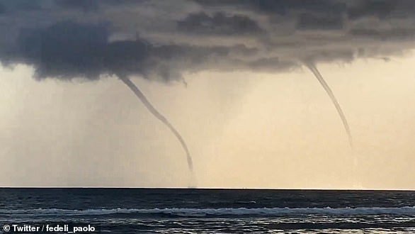 Waterspouts are swirling columns of air and water mist that form over water or move from land to water. Pictured: Two waterspouts are seen over the sea at Fregenae