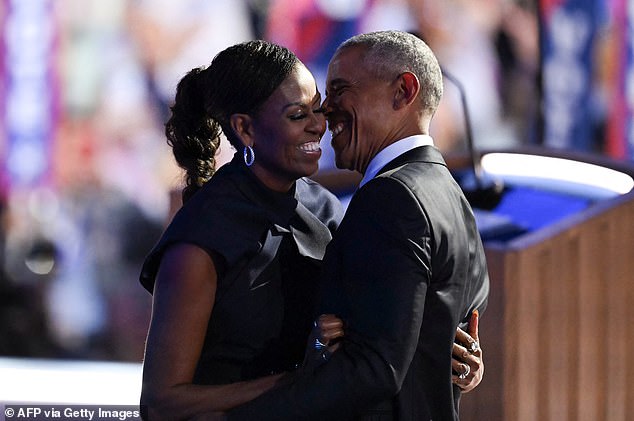 The former first lady embraces her husband, former President Obama, before his speech