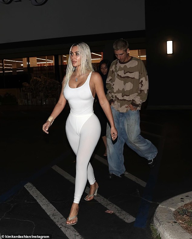 The photos show a blonde Kim leaving a Los Angeles supermarket in a sassy white leotard and tights