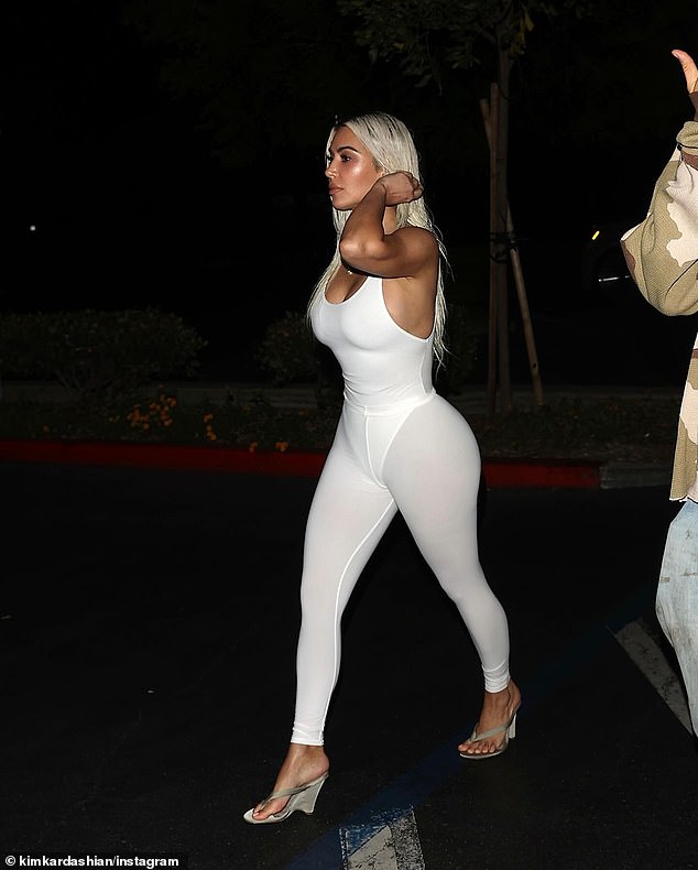 The tight outfit showed off her curves as she walked through the store's parking lot with her entourage