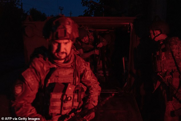 Ukrainian soldiers arriving from the frontline step out of a US-made M113 armored personnel carrier in an unidentified area in the eastern Donetsk region, August 5, 2024