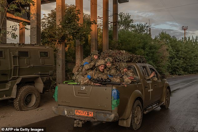 Ukrainian soldiers ride in a vehicle in an unidentified area in the eastern Donetsk region, on August 5, 2024