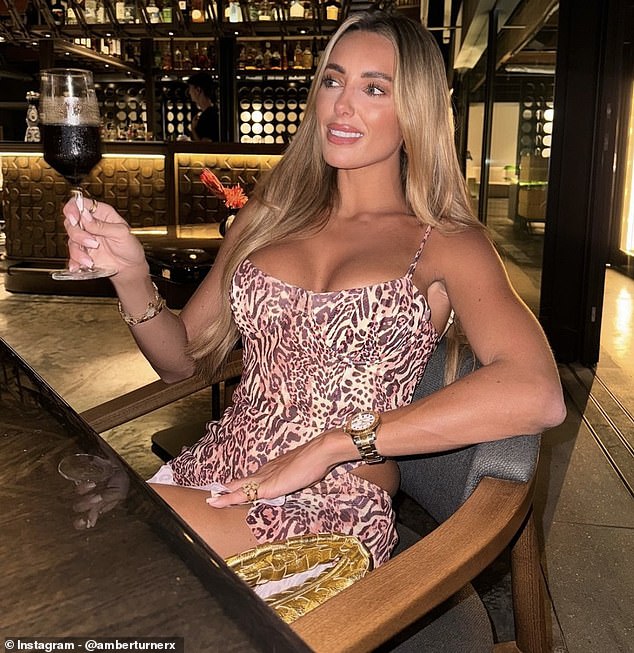 For another photo, Amber relaxed at a bar, wearing a gorgeous leopard-print sleeveless dress and holding a glass of wine