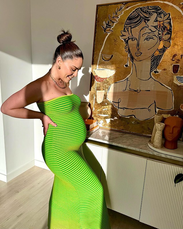 The former Neighbours star simply beamed as she showed off her baby bump in a tight, bright green dress