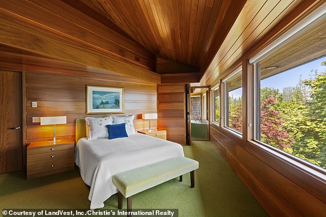 One of the bedrooms (pictured) is located at the bottom of the stairs and is covered from top to bottom in sleek wood and green carpet.