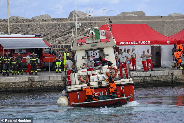 Divers recover a body from the sinking of the British yacht Bayesian yesterday. Two of the bodies were found in the same part of the ship