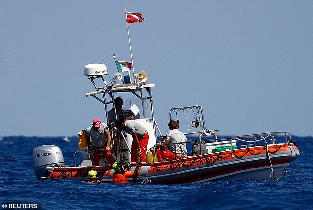 Rescue crews and divers operate on the water above the sunken superyacht yesterday