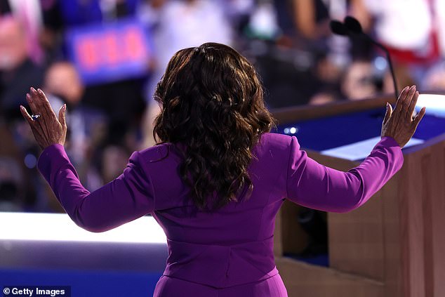 Oprah Winfrey raises her hands to the audience as she addresses the Democratic National Convention in Chicago, where her long-running daytime television program aired