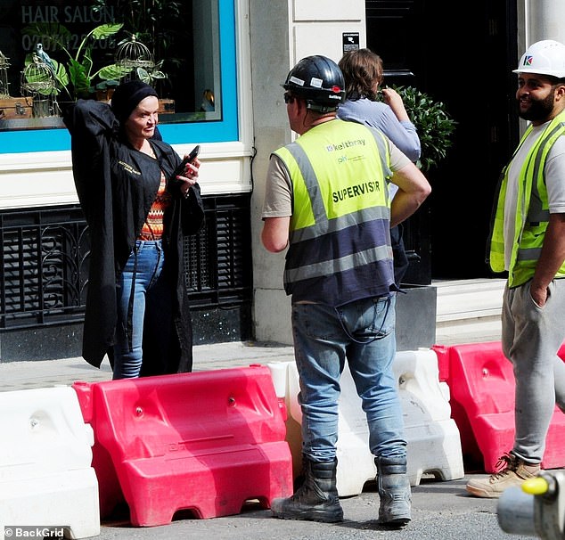 The mother of two was also spotted chatting with two construction workers while standing in the sun