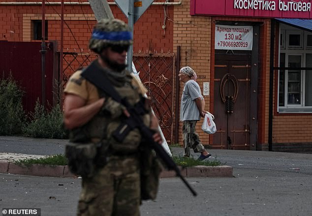 A Ukrainian soldier patrols an area in the Ukrainian army-controlled town of Sudzha, Kursk region, Russia