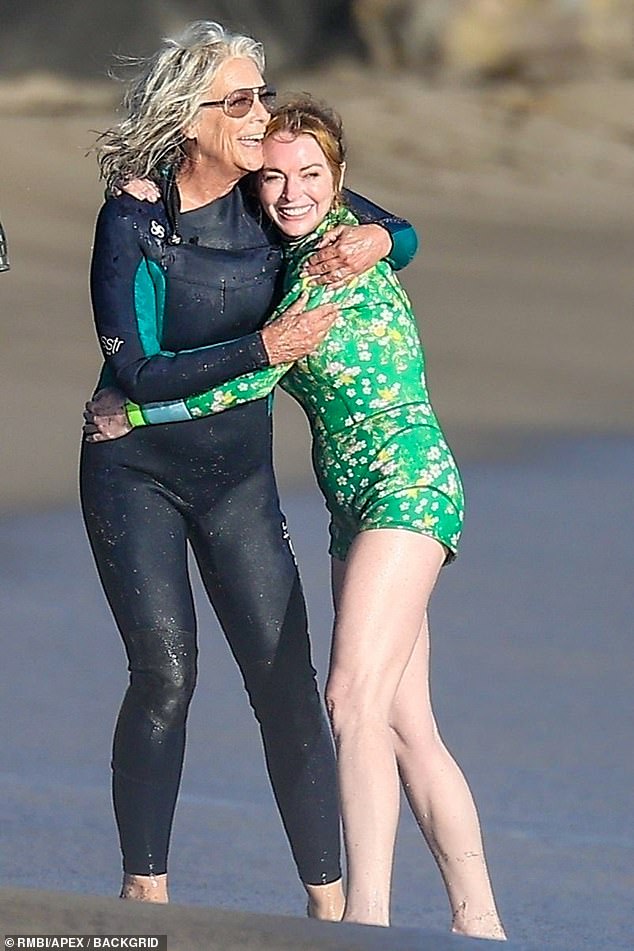 Cameras were rolling, Lohan was styled in a green wetsuit with a white floral print that showed off her endless legs