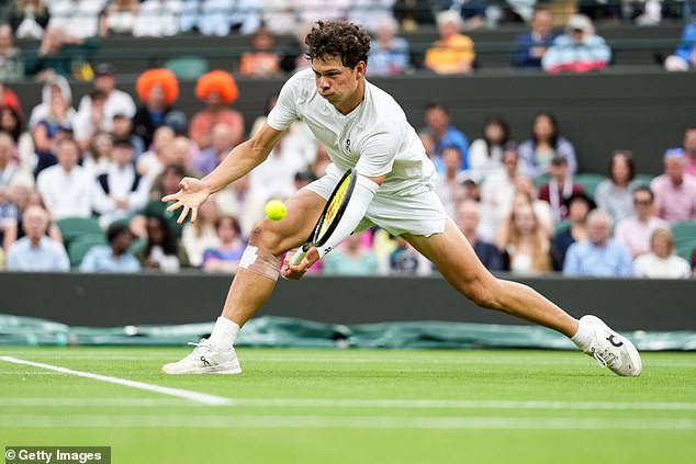 Shelton makes a return to the net during his match against Jannik Sinner at Wimbledon