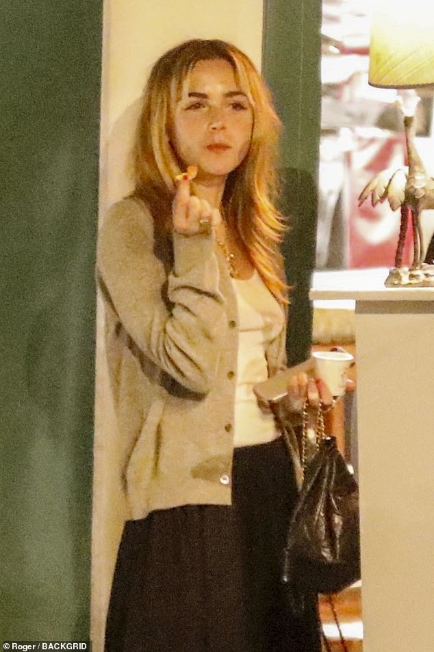 Kiernan looked chic in a black maxi skirt and a beige sweater over a low-cut white tank top