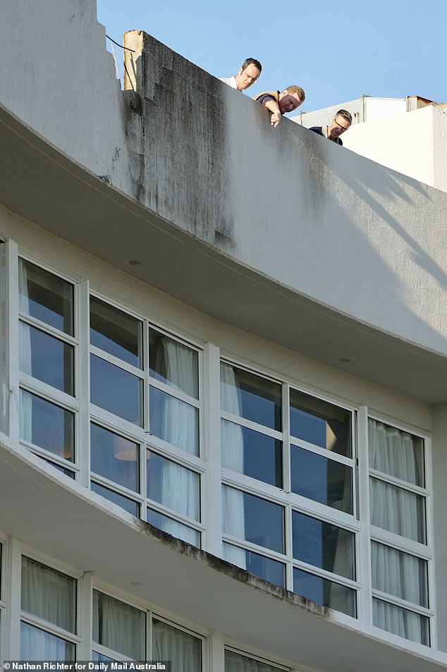 Witnesses reported seeing the plane flying dangerously low before it crashed into the roof of the hotel and burst into flames (pictured: investigators inspect the damage)