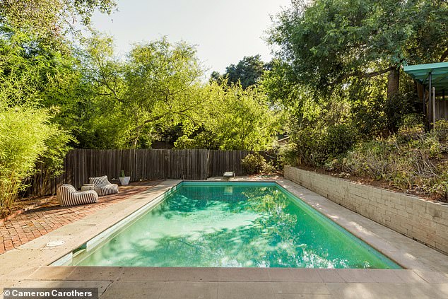 The backyard has a large heated pool, diving board and plenty of lounging space