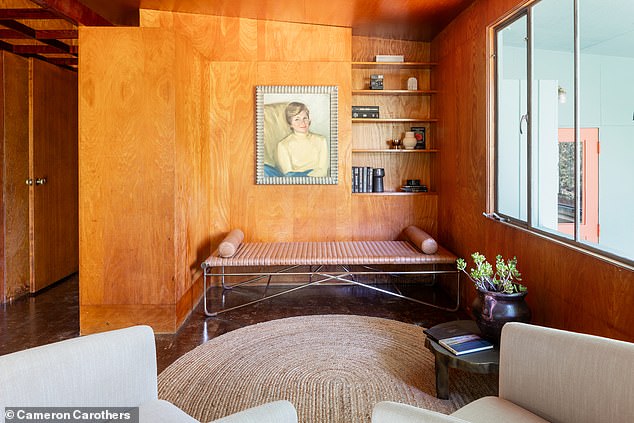 There is a cozy lounge area along the hallway with oak mosaic flooring with space for another sofa, lounge chair and several shelves for storage