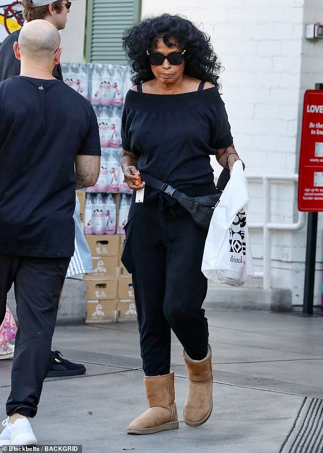 She wore a black off-the-shoulder top, black leggings and a matching fanny pack, leaving her hands free to carry her groceries and wave to her fans.