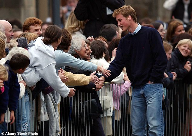 Prince William shakes hands with people in the crowd outside St Andrews University