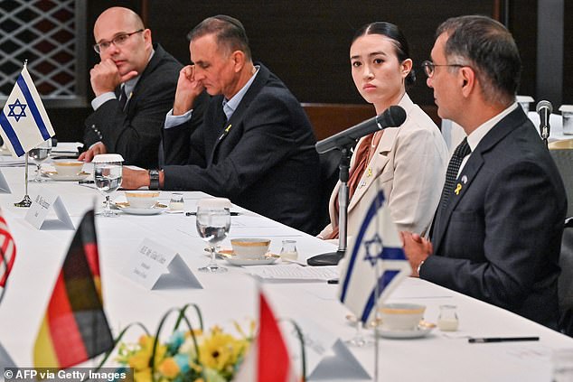 Noa listens to Israeli Ambassador to Japan Gilad Cohen (R) speaking during a meeting with representatives of the G7 embassy during a visit to Tokyo on August 21